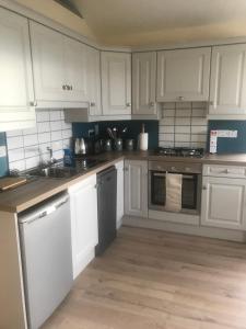 a kitchen with white cabinets and a sink at The Stable Self Catering Cottage @ Cappa House BnB in Eyeries +20 photos