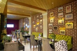 a restaurant with tables and chairs and a brick wall at Lahore Continental Hotel in Lahore