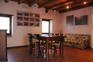 a dining room with a table and chairs and a couch at Corte Spinosa in Negrar