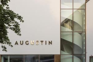 a glass building with a sign that reads augustin at Jugend- und Familienhotel Augustin in Munich