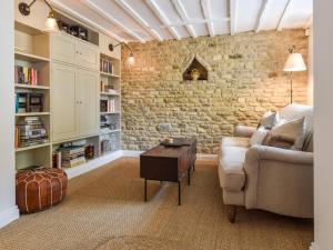 a living room with a couch and a brick wall at Browns Cottage in Chipping Norton