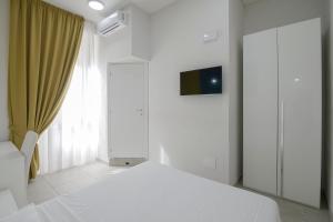 a white bedroom with a bed and a window at La Chambre in Naples