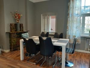 a dining room with a white table and black chairs at Go Happy Home Vilhonkatu 9. Stylish home in the heart of the city centrer in Helsinki