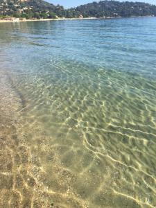 um corpo de água limpo com uma praia de areia em Grand Hotel Moriaz em Le Lavandou