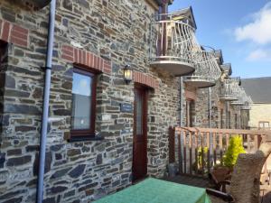 a brick house with a balcony with a table and chairs at The Stores in Aberystwyth