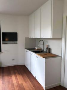 纳尔多Sunny Apartments的带白色橱柜和水槽的厨房