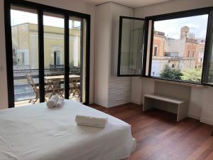 纳尔多Sunny Apartments的带白色床和大窗户的卧室