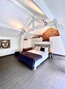 a bedroom with a large bed and a brick wall at LE REFUGE D'ELI - Le Gîte in Vitrival