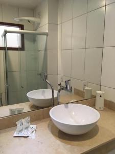 W łazience znajduje się biała umywalka i lustro. w obiekcie Indulge and Relax Apartment w mieście Pipa