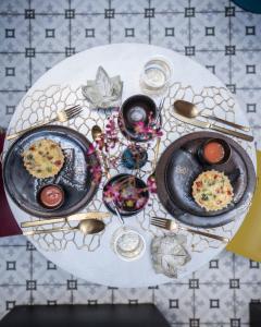 a table with two plates of food on a table at Lit d'Art Exclusive Boutique Hotel in Antwerp