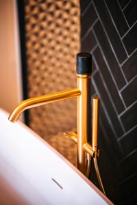 a close up of a gold piping in front of a mirror at Lit d'Art Exclusive Boutique Hotel in Antwerp