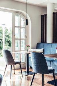una sala da pranzo con divano blu e tavolo e sedie di Hotel Dermuth Klagenfurt a Klagenfurt