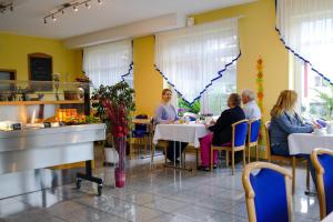 a group of people sitting at tables in a restaurant at Hotel Landgasthof Lell in Künzelsau