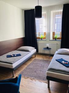 1 dormitorio con 2 camas y alfombra en Caffe Boulevard Penzion, en Waldsassen