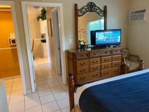 een slaapkamer met een dressoir en een televisie bij Casitas Coral Ridge in Fort Lauderdale