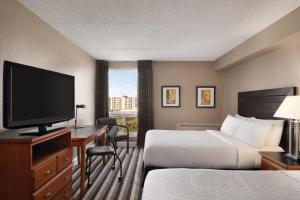 um quarto de hotel com duas camas e uma televisão de ecrã plano em Royal Hotel Regina, Trademark Collection by Wyndham em Regina