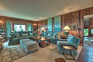 een woonkamer met blauwe meubels en houten wanden bij Charming Historic Family Home with Mountain Views! in Blowing Rock