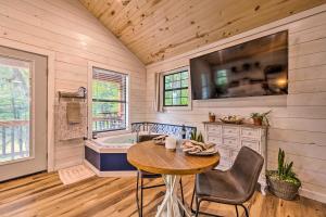 a kitchen with a table and a bath tub at Romantic Broken Bow Cabin with Jacuzzi and Fire Pit! in Broken Bow