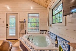a bathroom with a large tub in a house at Romantic Broken Bow Cabin with Jacuzzi and Fire Pit! in Broken Bow