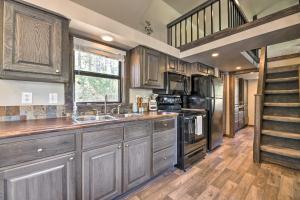 a kitchen with wooden cabinets and a staircase at Roomy Pagosa Springs Tiny Cabin 1 Mi to Downtown in Pagosa Springs