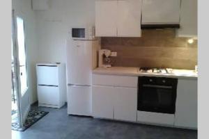 uma cozinha com electrodomésticos brancos e um frigorífico branco em GITE à LA FERME PRES VULCANIA-GR89 em La Goutelle