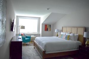 a bedroom with a bed and a desk and a window at Tilghman Island Inn in Tilghman Island