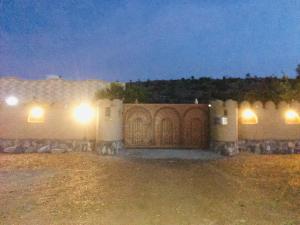 un cancello per una casa di notte con luci di Al Wafa House a Sa‘ab Banī Khamīs