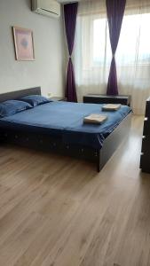 大特爾諾沃的住宿－Panorama Apartment & Rooms Veliko Turnovo，一间卧室配有一张带蓝色床单和紫色窗帘的床