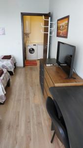 a room with a desk with a television and a bedroom at Panorama Apartment & Rooms Veliko Turnovo in Veliko Tŭrnovo