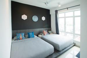 a bedroom with two beds and a window at Migliore Homestay in Ipoh