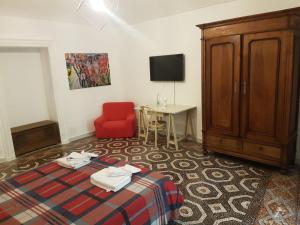 a room with a bed and a desk and a tv at B&P La Gusteria in Ivrea