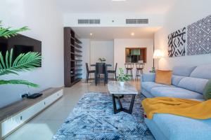 a living room with a blue couch and a table at GuestReady - Panoramic View of Dubai Skyline in Dubai