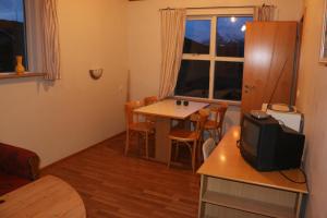 Habitación pequeña con mesa y TV pequeña. en Stafafell Cottages, en Stafafell