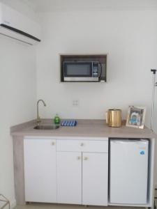 a kitchen with a sink and a microwave on the wall at Ocean Front Property - Villa 4 Aruba w pool view in Savaneta