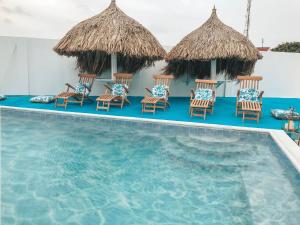 Un grupo de sillas junto a una piscina. en Ocean Front Property - Villa 4 Aruba w pool view, en Savaneta
