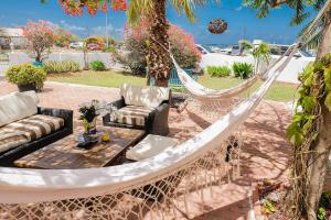 una hamaca en un patio con mesa y sillas en Ocean Front Property - Villa 5 Aruba Stunning, en Savaneta