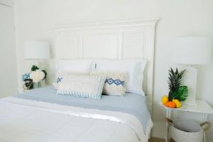 1 dormitorio blanco con 1 cama con cabecero blanco en Ocean Front Property - Villa 5 Aruba Stunning, en Savaneta