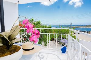 Un balcón con una mesa con flores. en Ocean Front Property - Villa 5 Aruba Stunning, en Savaneta