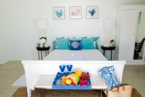 Una cama blanca con una bandeja de fruta. en Ocean Front Property - Villa 5 Aruba Stunning, en Savaneta