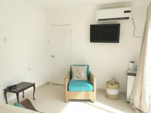 a room with a chair and a tv on a wall at Big Room A Spectacular Beach Front View in Savaneta