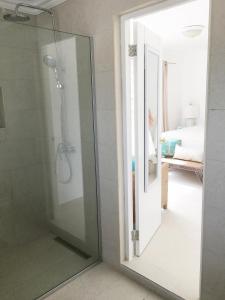 a shower with a glass door in a bathroom at Big Room A Spectacular Beach Front View in Savaneta