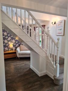 a white staircase in a living room with a couch at Contractor Accommodation Antrim in Aldergrove