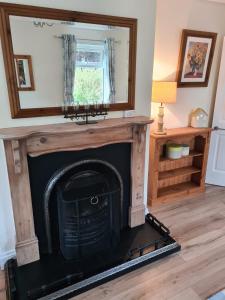 a fireplace in a living room with a mirror at Contractor Accommodation Antrim in Aldergrove