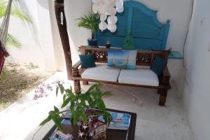 a blue bench sitting in a room with a plant at Apartment Brazil Beach Front Paradise in Savaneta
