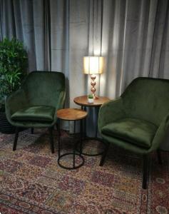 twee stoelen en een tafel met een lamp in een kamer bij Hotell Marieberg in Kristinehamn