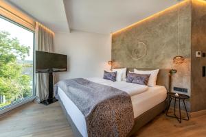 a bedroom with a large bed and a large window at Moselromantik Hotel Kessler Meyer - Adults Only in Cochem +106 photos