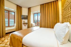 a bedroom with a large white bed and a window at Sintra Boutique Hotel in Sintra