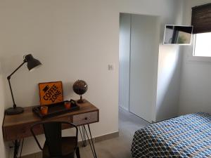 ルマンにあるChambre d'hôtes du Muguet avec SdB privativeのベッドルーム1室(ベッド1台、ランプ付きデスク付)