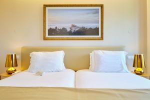 two beds in a hotel room with two lamps at Sintra Boutique Hotel in Sintra