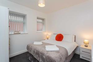 Un dormitorio con una cama con una almohada roja. en Cherry Property - Orange Suite, en Blackpool